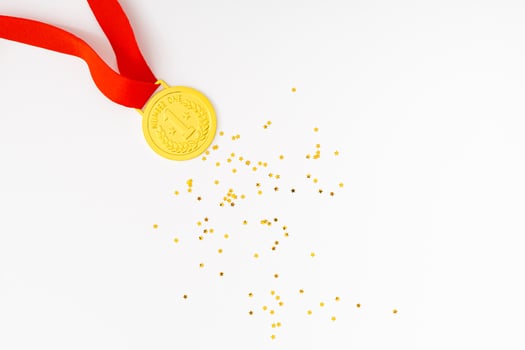 Golden medal on white background with golden glitter stars. Creative winner concept. Minimal victory backdrop idea. Flat lay. photo