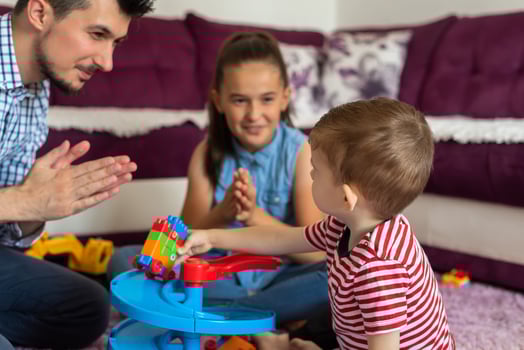 Happy family a young father with children playing together with toys on the floor in the living room. photo