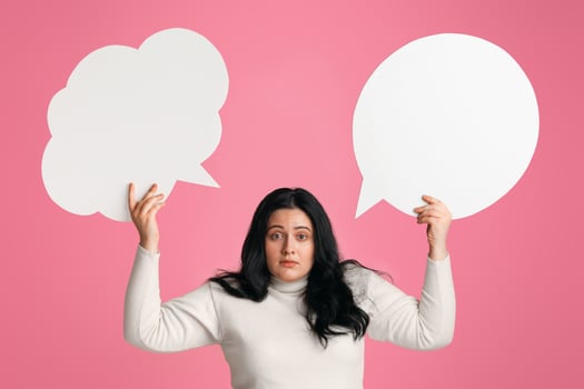 Complex Desicion. Puzzled Obese Girl Holding Two Empty Speech Bubbles Above Her Head And Looking At Camera, Panorama photo