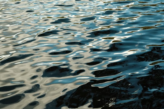 The view of a rippled water surface beautifully reflecting the warm light photo