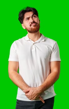 A man contemplates thoughtfully against a bright green background photo