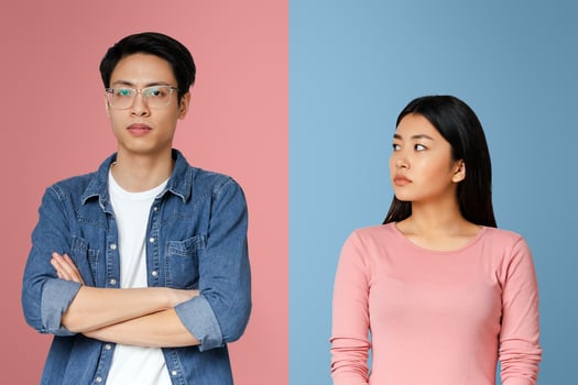 I am sorry. Sad asian girl looking at her angry boyfriend over grey background photo