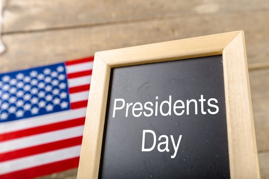 the text happy presidents day written in a chalkboard and a flag of the United States photo
