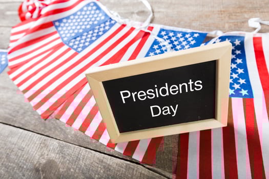 the text happy presidents day written in a chalkboard and a flag of the United States photo