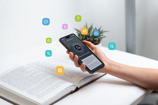 Hand holding smartphone above open book, using voice-to-text app for learning, representing audio search and text-to-speech technology, with floating icons for study and communication concepts photo