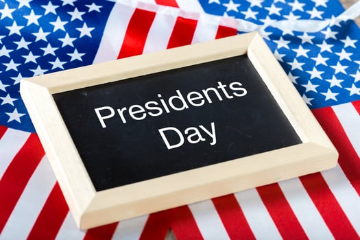 the text happy presidents day written in a chalkboard and a flag of the United States photo