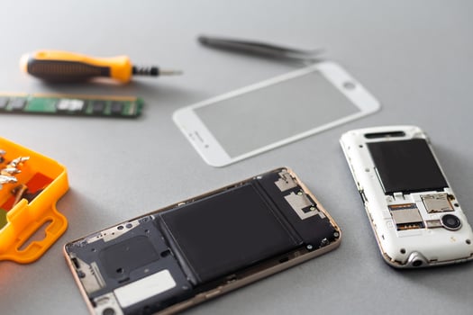 Technician repairing mobile phone at table, closeup photo