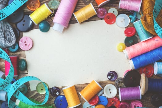 Colored threads centimeter and buttons, pair of scissors on the table. Copy space photo