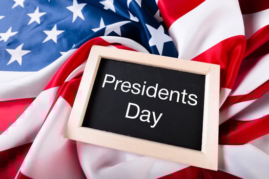 the text happy presidents day written in a chalkboard and a flag of the United States photo