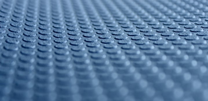 Round embossed pattern on a blue porous material with defocused top and bottom edges. 3d background stock photo