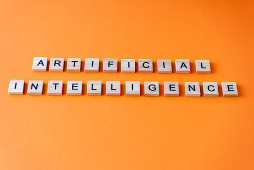 Word artificial intelligence. The phrase AI is laid out in wooden letters top view. Orange flat lay background. photo