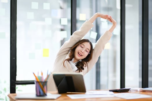Businesswoman stretching at her desk during a break in the office photo