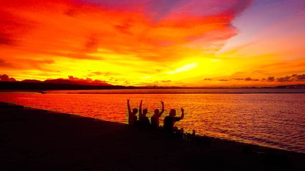 A stunning sunset in Indonesia paints the sky in vibrant oranges and reds. People gather, savoring the breathtaking view and the tranquility it brings. photo