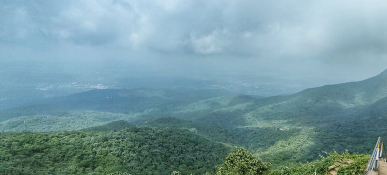 A man is standing on a hill overlooking the mountains photo