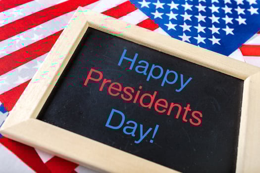 the text happy presidents day written in a chalkboard and a flag of the United States photo