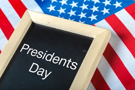 the text happy presidents day written in a chalkboard and a flag of the United States photo
