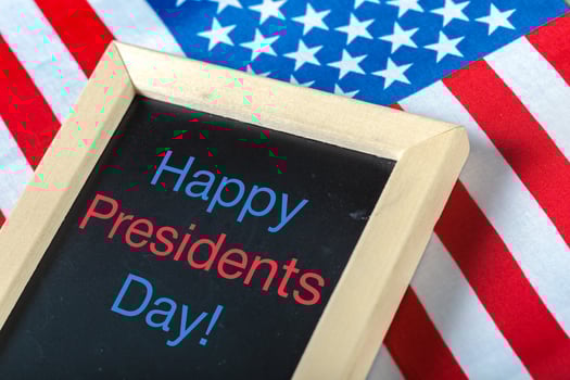 the text happy presidents day written in a chalkboard and a flag of the United States photo