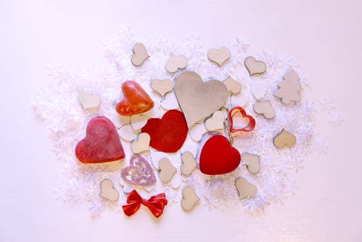 Artificial snowflakes and red decorative hearts on white soft background photo