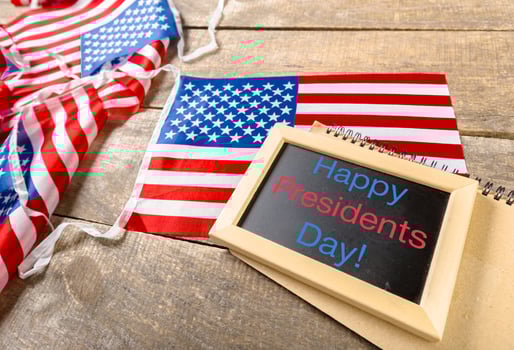 the text happy presidents day written in a chalkboard and a flag of the United States photo