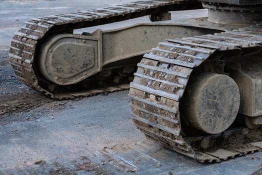 Heavy machinery track resting on a construction site in daylight photo