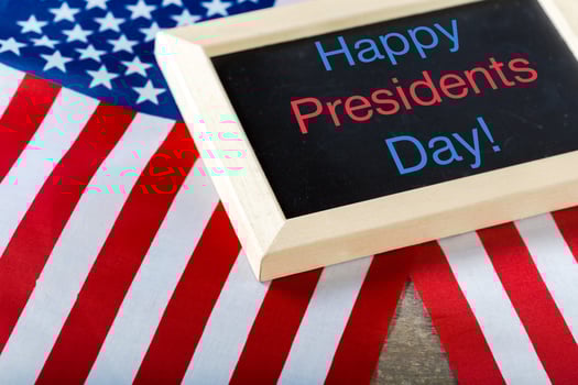 the text happy presidents day written in a chalkboard and a flag of the United States photo