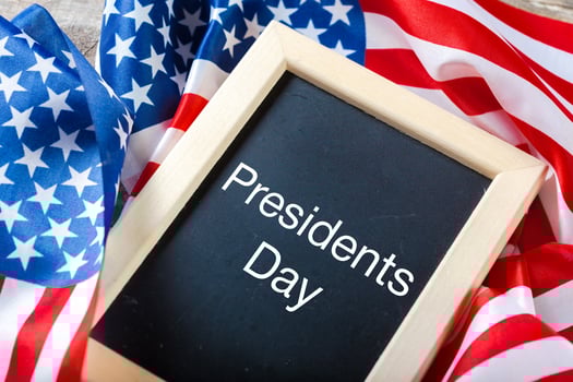 the text happy presidents day written in a chalkboard and a flag of the United States photo