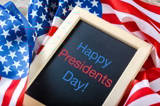 the text happy presidents day written in a chalkboard and a flag of the United States photo
