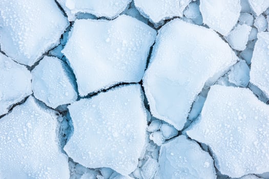Frozen lake surface with cracked ice photo