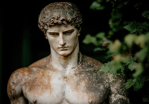 Weathered ancient statue in lush garden photo