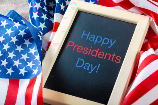 the text happy presidents day written in a chalkboard and a flag of the United States photo