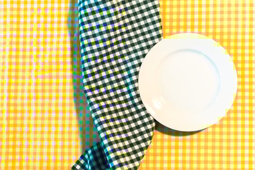 the plate on yellow checkered table cloth photo