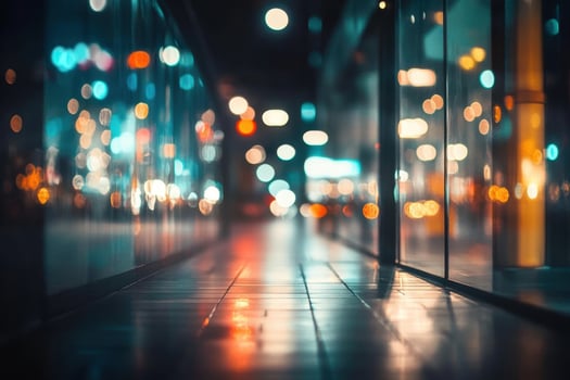 A city street at night, with the lights of the city reflected in the windows of a building. photo