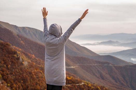 Happy woman enjoying rise hand up on top of mountain. Concept of free freedom. photo