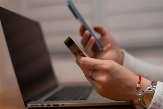 Female hands using mobile phone and holding credit card checking balance or making money transfer. Online Payment Internet Banking Concept. Woman using smartphone for online banking at home close up. photo