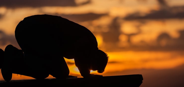 A Muslim prayer man praying at sunset. photo