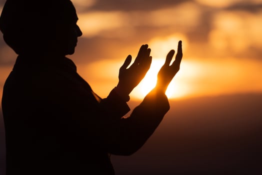 Muslim woman prayer praying with hands up open doing dua at sunset worship Allah. photo