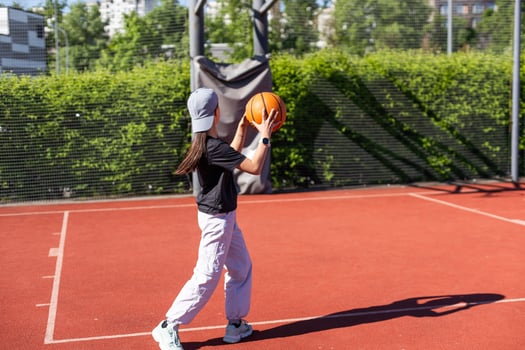 Girl with a basketball on the background of the city. Street basketball. photo