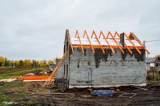 A house is currently being constructed using wooden beams for the roof photo