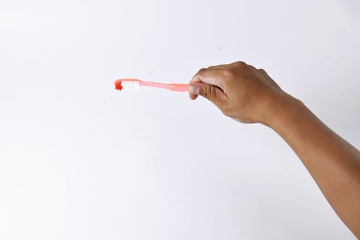 a man's hand holding a toothbrush on a white background photo