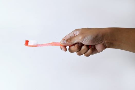 a man's hand holding a toothbrush on a white background photo