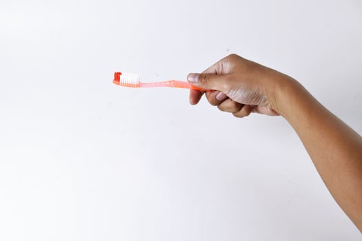 a man's hand holding a toothbrush on a white background photo