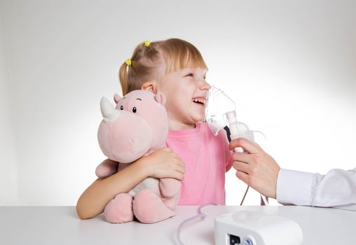 A 5-year-old girl breathes into an inhaler to dilute sputum in case of lung diseases. Treatment of cough in children. Nebulizer therapy photo