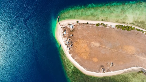 Discover breathtaking aerial views of Kenawa Island in the blue sea, featuring a small hill and vast savanna in the uninhabited area of Sumbawa, Nusa Tenggara Barat. photo