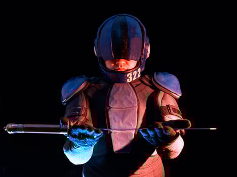 Cyberpunk future concept. Bionic cyborg police officer with short samurai sword stands in dark. Halfman robot looks at camera. Futuristic science fiction scene. photo