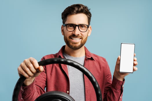 Smiling, handsome bearded Hispanic man wearing eyeglasses, holding mobile phone with empty screen photo