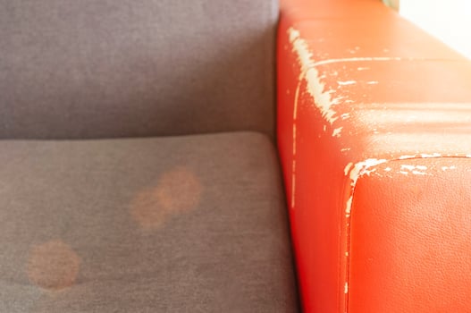 Torn and battered leather back of the sofa. Poor quality leather, leather cleansing and restoration photo