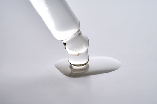 Dropper pipette with delicious serum with drop close-up. photo