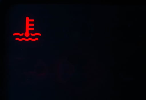 Red indicator of car engine coolant on a black background. Car overheating concept, copy space for text photo