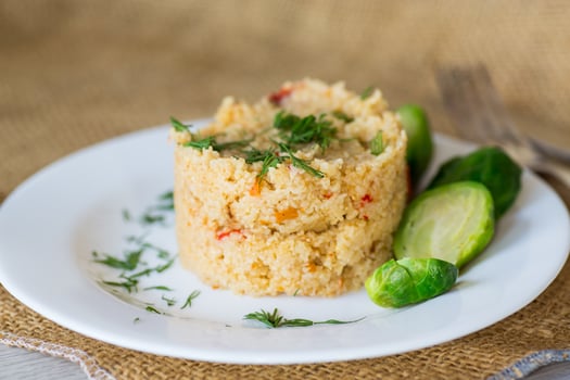 homemade cooked bulgur with Brussel sprouts in a plate, on a wooden table photo