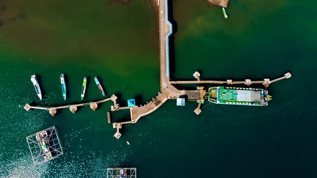 Aerial views of the harbor leading to Labuan Bajo, featuring deep blue waters and a clear sky, with boats ready to sail towards the Labuan Bajo, Indonesia photo